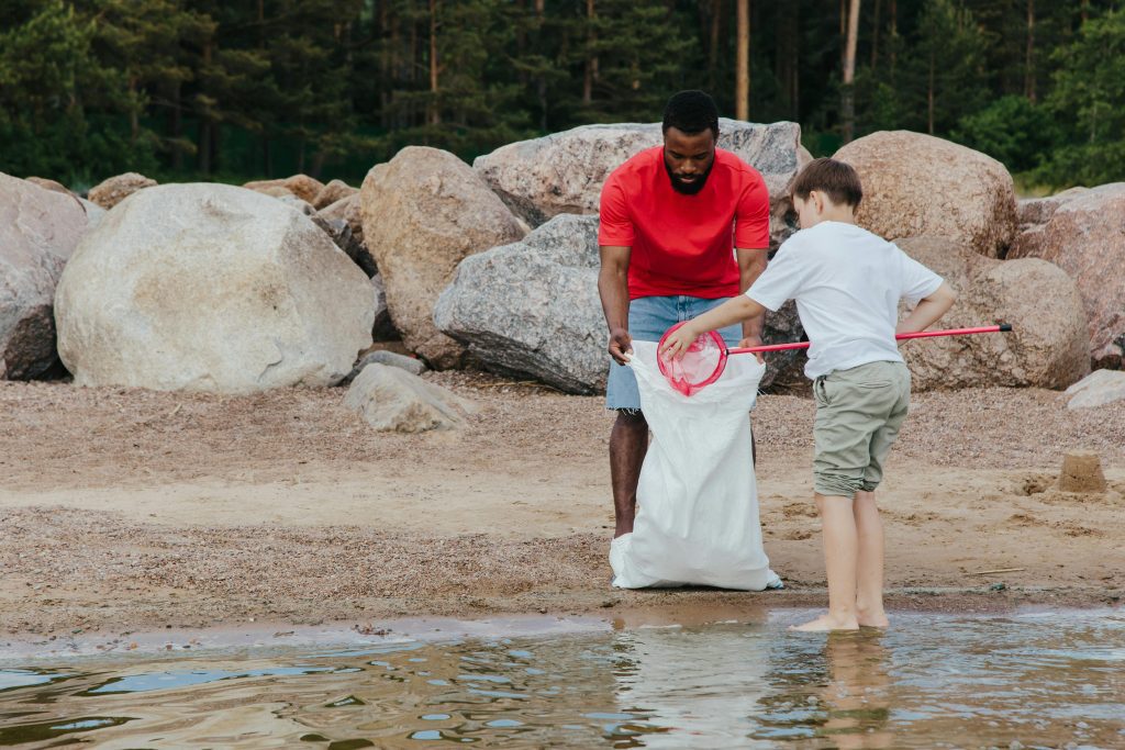 A boy and man cleaning a river